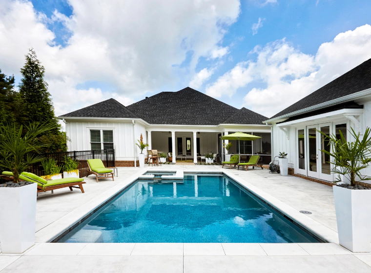 A luxurios pool with plants around it